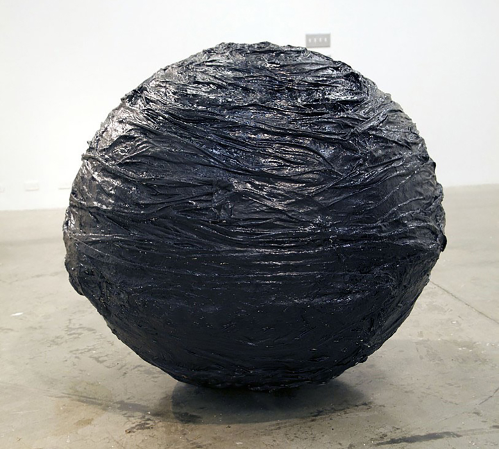 Image of a large black textured sphere, ther surface appears slimy