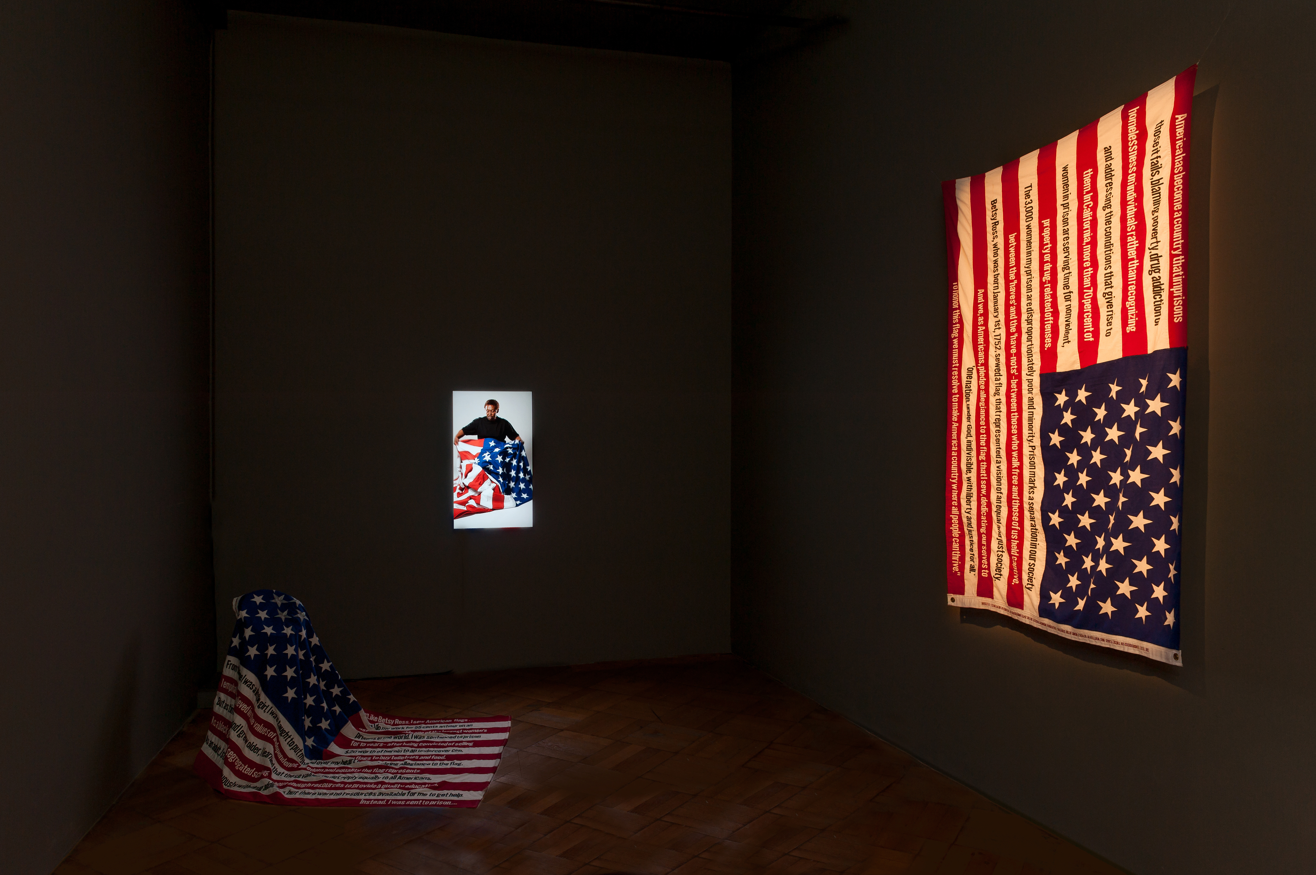 Image of installation with two U.S. flags and a video